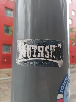 A sticker featuring the text SOUTH SIDE STOCKHOLM. The sticker has a worn look, suggesting it has been affixed to a surface for some time. 