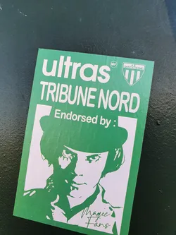 Street sticker Green and white sticker featuring a stylized portrait of a person wearing a bowler hat, reminiscent of a character from the movie A Clockwork Orange.  The sticker also includes the text "Ultras TRIBUNE NORD" and "Endorsed by:" with the signature of "Magic Fans". A small logo for AS Saint-Étienne is present.