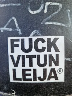 Street sticker A square white sticker with black bold text.  The text says "FUCK VITUN LEIJA" with a registered trademark symbol. The phrase is offensive. 