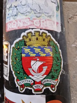 A sticker featuring the coat of arms of Nice, France. The coat of arms depicts a castle, cannons, an ancient ship, and a laurel wreath. The Latin motto "FLUCTVAT NEC MERGITUR" is visible at the bottom, meaning "It is tossed but does not sink."