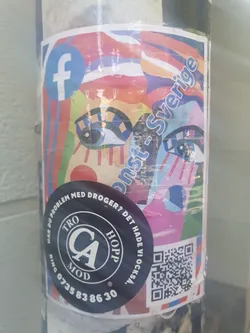 Street sticker A colorful sticker featuring an abstract artwork with eyes and the text "Konst-Sverige". It also includes a Facebook logo, a QR code, and a round sticker with text in Swedish, presumably about drug problems and hope, with a phone number. 
