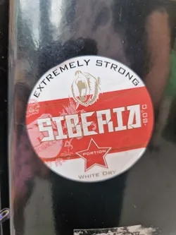 Round sticker featuring a roaring bear, text stating "Siberia" prominently, and additional details indicating "Extremely Strong", "Portion", and "White Dry". The color scheme is mainly red and white.