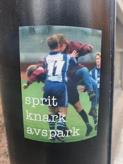 Street sticker This sticker features a dynamic image of a football match, showcasing players in action. The words 'sprit knark avspark', which translate from Norwegian to 'spirit drug kickoff', are printed below the image. The sticker's design is simple yet impactful.