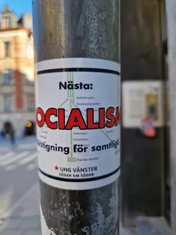 Street sticker A sticker promoting socialism, featuring a stylized map of a metro line and the text "Nästa: Socialism" ("Next: Socialism"). It also includes the name of a youth political organization: Ung Vänster Södermalm. 