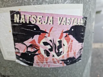 A sticker featuring four crows surrounding a stylized flame-like image on a pink background.  The text 'NATSEJA VASTAAN!' is prominently displayed at the top. The style is bold and graphic.