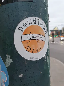 Street sticker A sticker for Jimmy's Deli, established in 2020. The sticker has an orange circle with the text 'Downtown' written around it and 'Jimmy's Deli' inside the circle. 