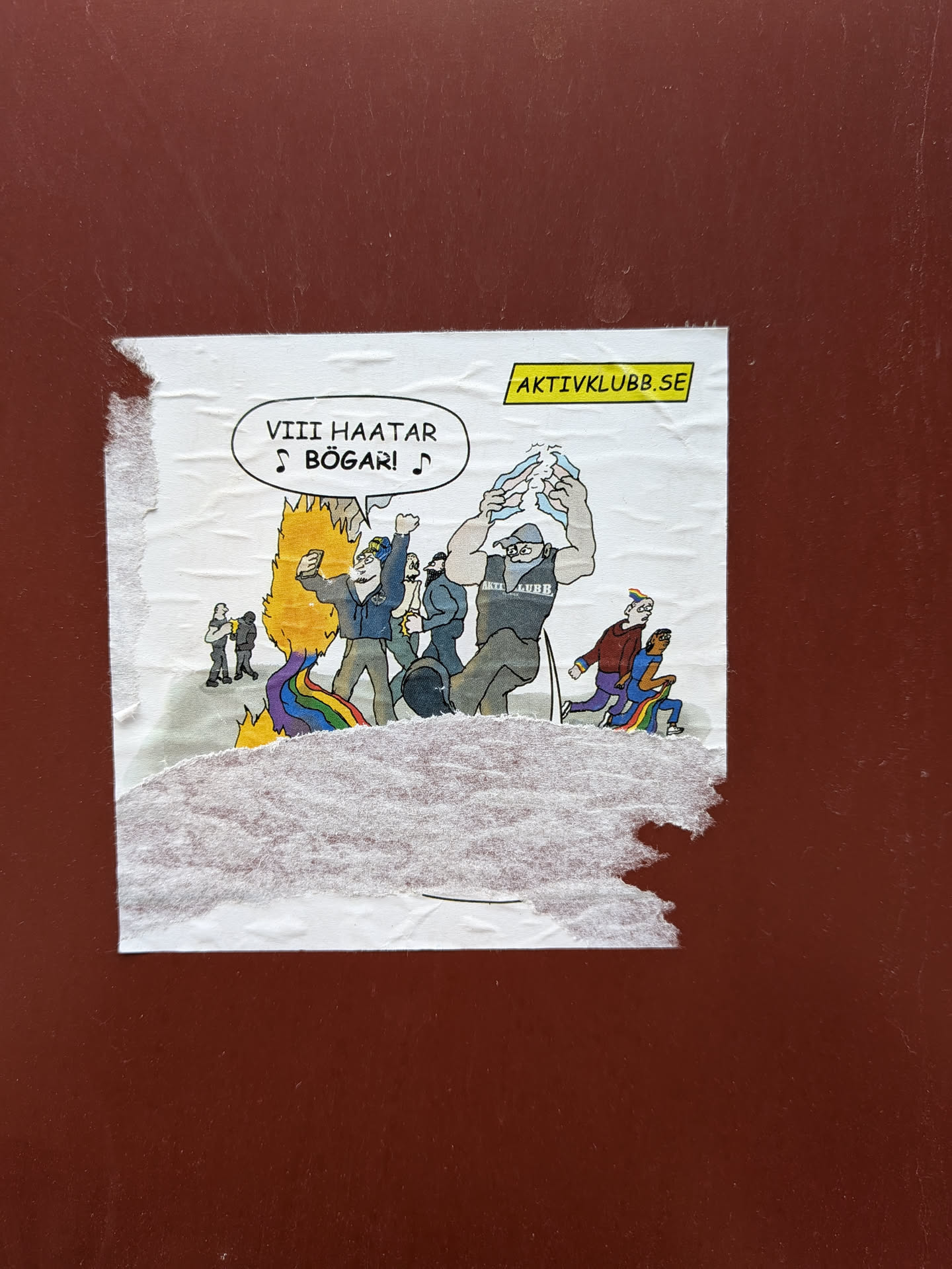The sticker displays a cartoon illustration on a white background, showing a group of male figures engaged in a scene of hostility towards the LGBTQ+ community. In the center, a rainbow-colored flag is depicted burning, with yellow and orange flames. One prominent figure, a man with a beard and blue jacket, raises his fist and holds a smartphone, seemingly taking a selfie in front of the burning flag. To his right, a large, muscular man in a grey tank top (with 'AKTIV KLUBB' visible) is tearing apart a white object above his head. Other figures are in the background, observing or participating. On the right side of the illustration, two figures are shown running away, one wearing a rainbow-striped hat and the other with rainbow-colored pants. A speech bubble in the top left corner contains the text 'VIII HAATAR ♪ BÖGAR! ♪'. In the top right corner, a yellow banner with a black border reads 'AKTIVKLUBB.SE'. The sticker itself is visibly creased, wrinkled, and torn, particularly along the bottom edge, indicating it is a physical item affixed to a surface.