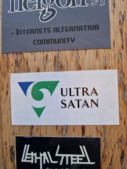 Street sticker White sticker with a green, blue and white triangle logo and the text "ULTRA SATAN" in black. 