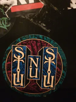Street sticker Round sticker with SNU logo in a unique design. The letters are stylized and enclosed within a circular frame with a dark background and teal border.  There's a small, barely legible inscription at the bottom.