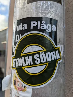 Street sticker A dark green and yellow sticker with the text "STHLM SÖDRA" in white lettering.  Part of a larger sticker is visible above, showing the words "Sluta Plåga Djuren" (Stop Torturing Animals).