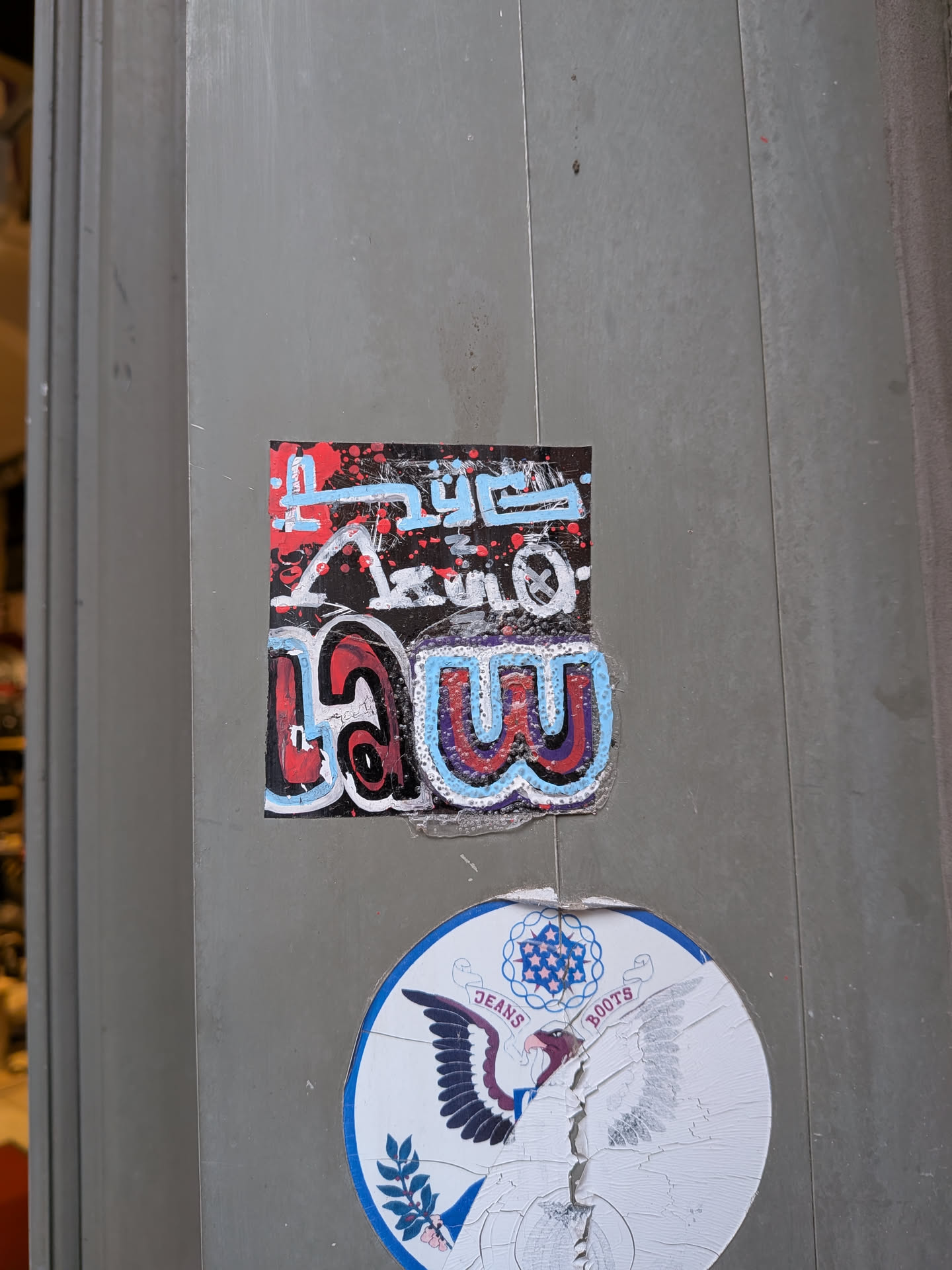 A rectangular sticker with a black background, featuring intricate graffiti-style lettering. The upper portion displays stylized text in light blue and white, with red paint splatters, appearing to spell 'TRUE'. The lower portion showcases larger, bubble-style letters in red, blue, and purple with white outlines, forming the word 'LAW'. The overall design is energetic and colorful, with visible texture and slight wear on the sticker's edges, indicating it's a physical sticker adhered to a surface.