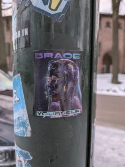 Street sticker The sticker showcases a stylized, dark-toned human head in profile, facing left, rendered with a metallic or glossy finish. The eyes glow with an intense green light, and the head is surrounded by sharp, luminous lines in shades of purple, blue, and pink, giving it a futuristic, digital, or holographic appearance. The background is dark, almost black, with faint, repeated vertical text. The word 'BRACE' is prominently displayed in purple block letters at the top, and 'YOURSELF' in teal block letters at the bottom, completing the phrase 'BRACE YOURSELF'. The overall aesthetic is reminiscent of cyberpunk or sci-fi themes, with elements of glitch art and neon lighting.