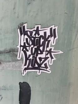 Black and white sticker with graffiti-style lettering. The text says "A SICK UP THING". The sticker is on a light green surface.