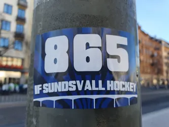 Street sticker A blue and white sticker featuring the number 865 and the text "IF Sundsvall Hockey". The design includes a stylized graphic resembling a bridge or arches beneath the text.