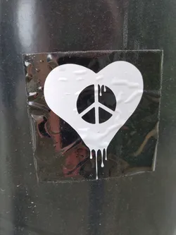 A sticker featuring a white heart with a peace symbol inside, with paint dripping from the bottom. It's a simple yet powerful message of peace and love.