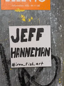 Street sticker The sticker features the name "JEFF HANNEMAN" written in a bold, handwritten-style font. Below the name, there's a hashtag #iron_fist_art indicating the artist or collective behind the sticker.