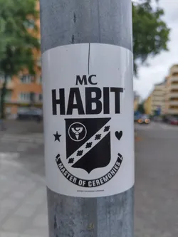 A black and white sticker featuring the text 'MC HABIT' and a crest-like design. The text 'Master of Ceremonies' is also written below the crest. The style is minimalist and bold.