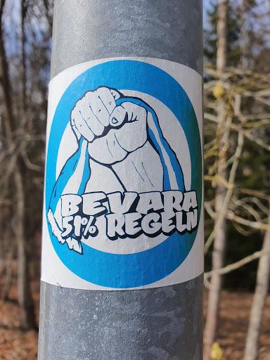 Street sticker The sticker features a stylized fist clutching a ribbon, set against a blue circular background. The text "BEVARA 51% REGLN" is prominently displayed beneath the fist.  The image suggests a message of preserving or maintaining something, possibly related to a rule or regulation (51% possibly referring to a majority).