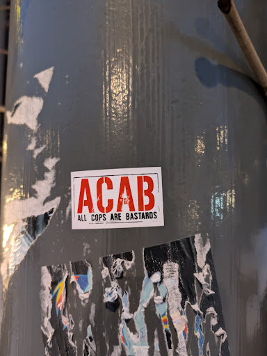 Street sticker A red and white sticker with the acronym ACAB and the words "All Cops Are Bastards" printed on it.