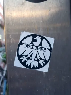 Black and white circular sticker featuring a stylized bird emblem with text. The text includes 'WETTERAU' and 'SG EINTRACHT FRANKFURT 1909'.