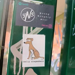 A sticker featuring a cartoon dog sitting and holding a piece of paper. The artist's name, nelly ziegenbein, is written below the illustration.