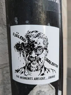 Black and white sticker featuring a stylized illustration of a man with glasses and a distressed appearance. Text on the sticker includes "SJÄLENS DIALEKIK" and "THE MOMENTS ARE LOST... JIMMIE".