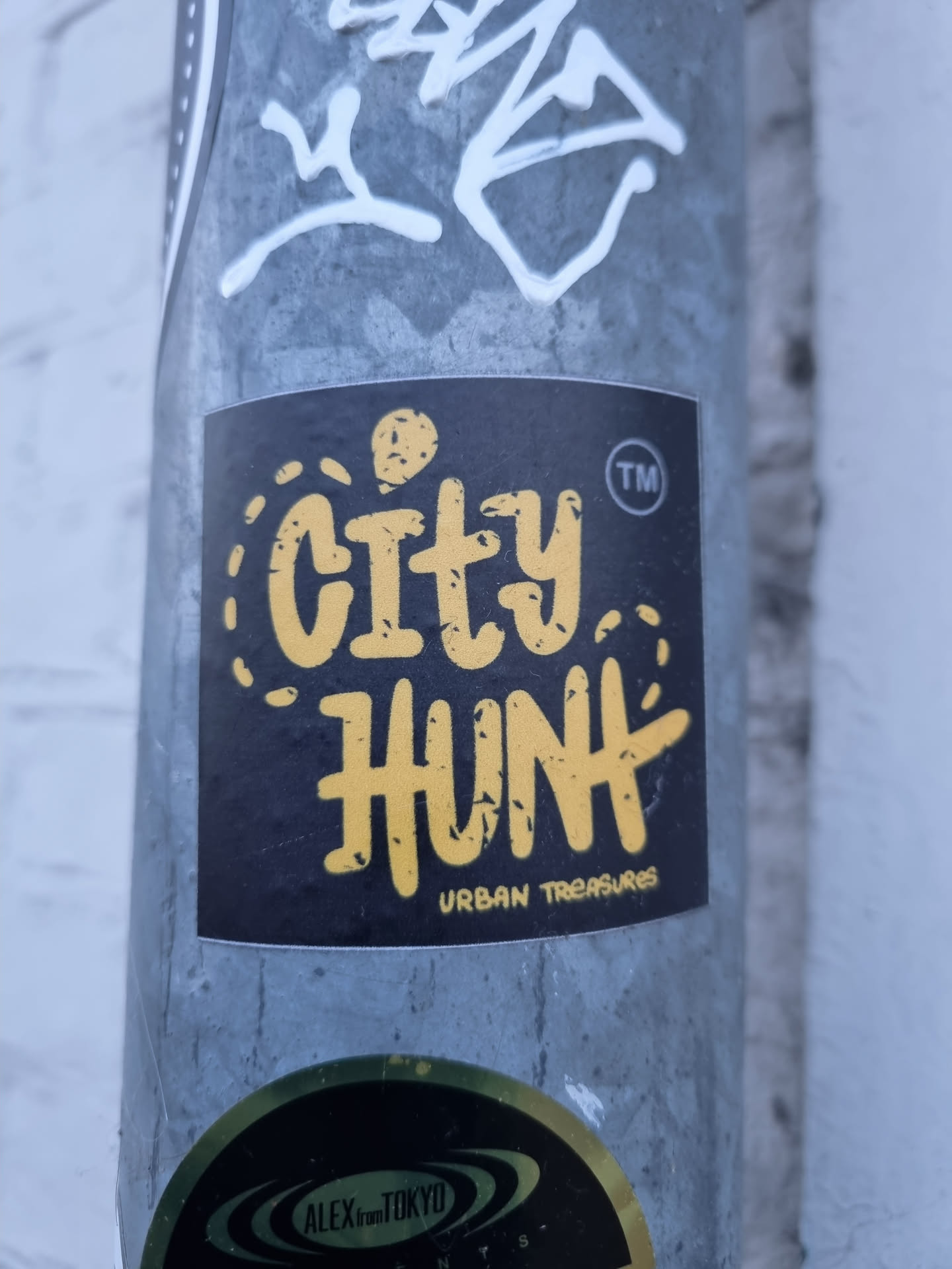 A black sticker with the text City Hunt in yellow.  The words "Urban Treasures" are written in smaller text below the main text. There is a small ™ symbol next to the word Hunt.