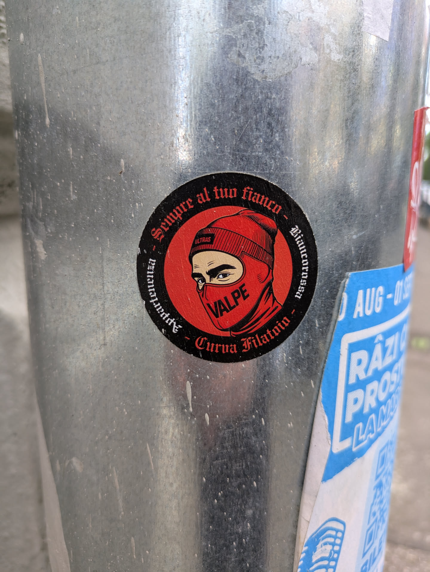 A round sticker with a black background and a red design. It features a person wearing a red balaclava with the word "VALPE" written on it. The sticker also contains the text "Sempre al tuo fianco - Biaucorosso - Appartenenza - Curva Filatoio".