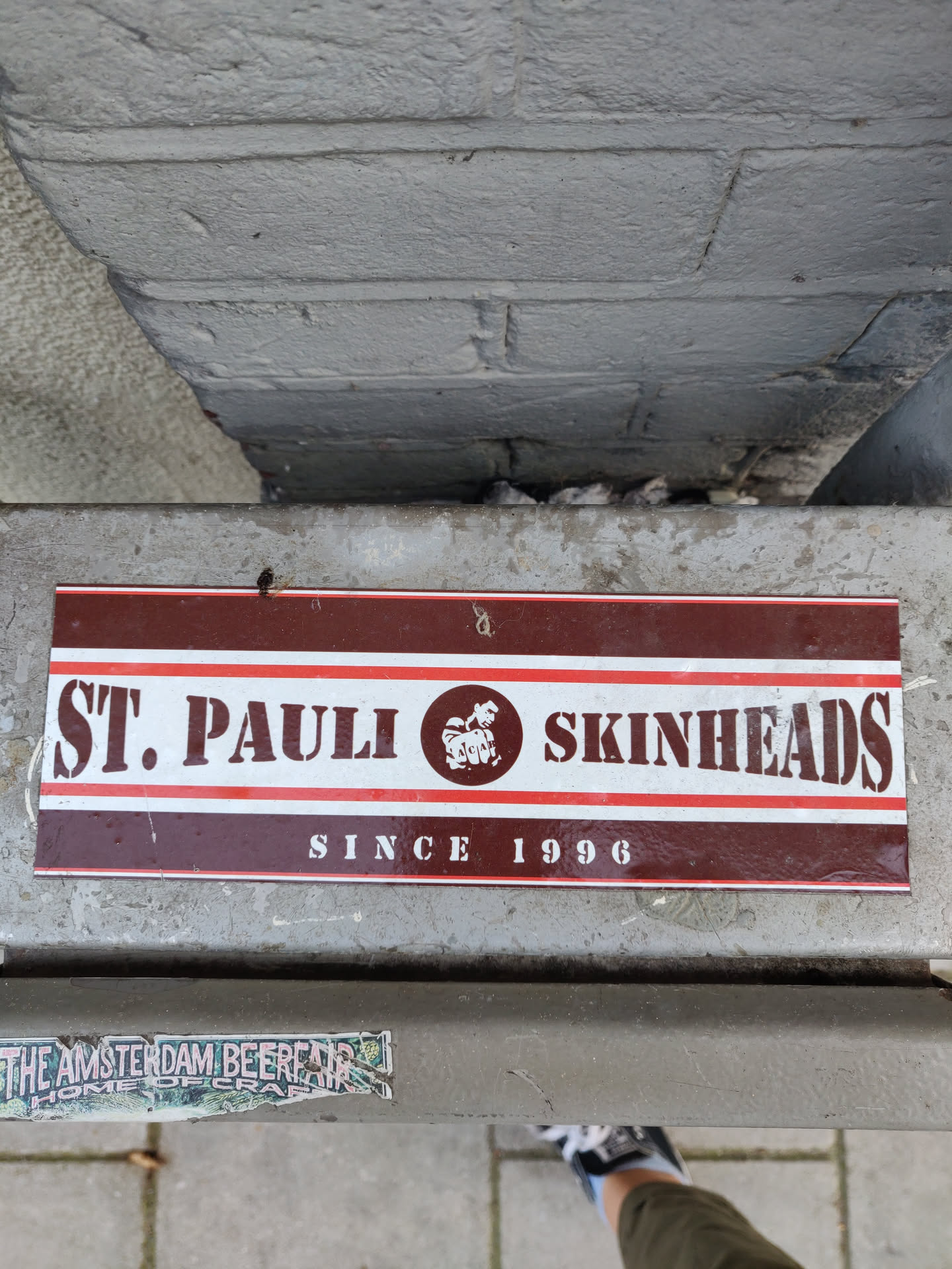 A brown and white sticker with the text "St. Pauli Skinheads" and "Since 1996". There is also a logo of a hop in the center.