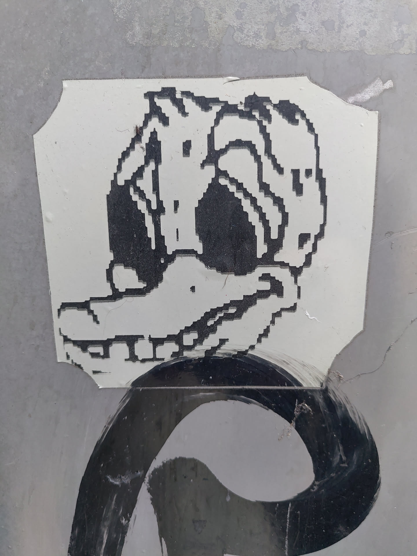 A sticker featuring a pixel art rendition of a duck. The duck is depicted in black and white, with a slightly distorted and mischievous expression.