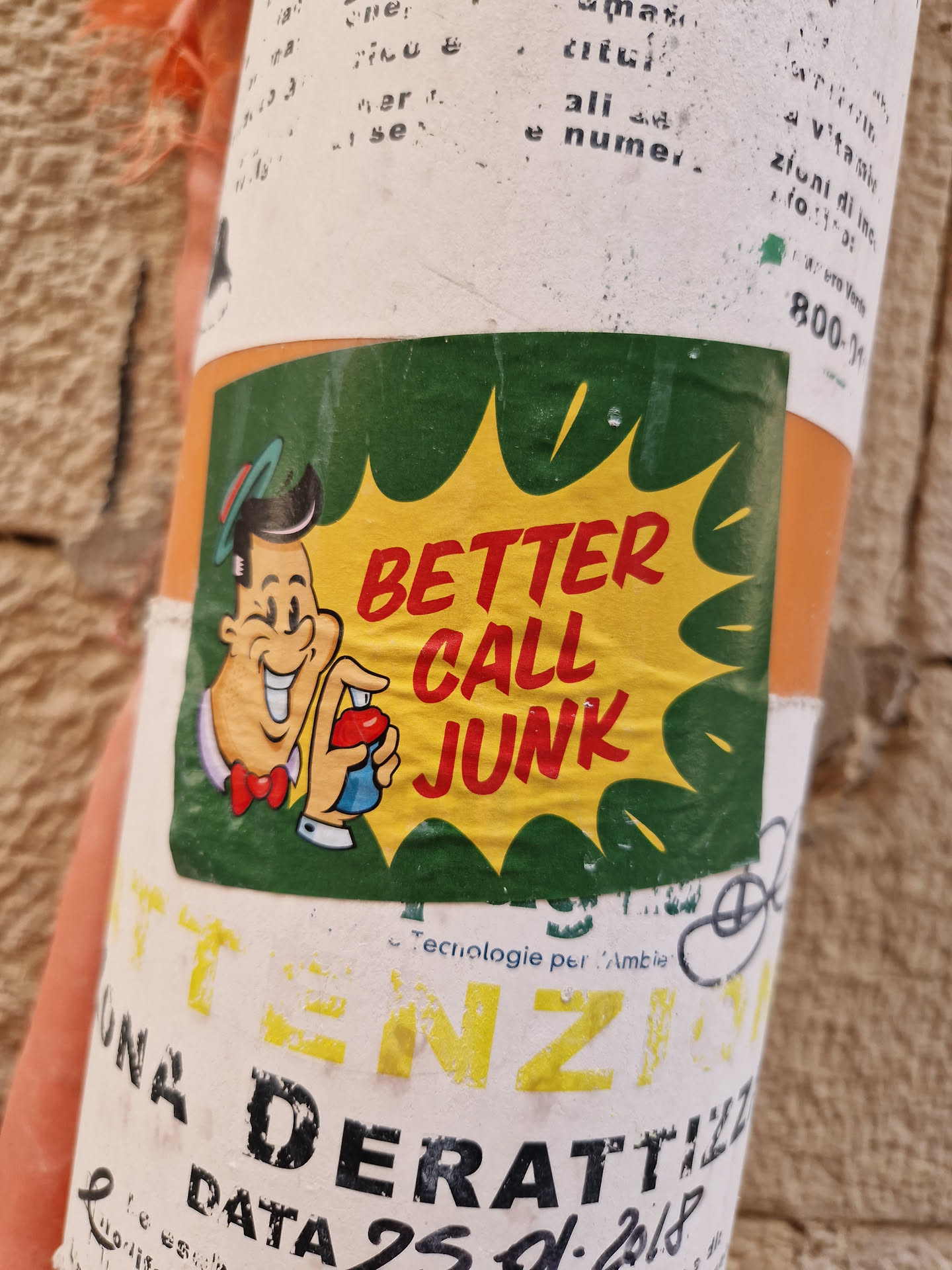 A vintage-style sticker featuring a cartoon character and the text "Better Call Junk". The sticker has a green and yellow color scheme. It's been affixed to what appears to be a cylindrical object. 