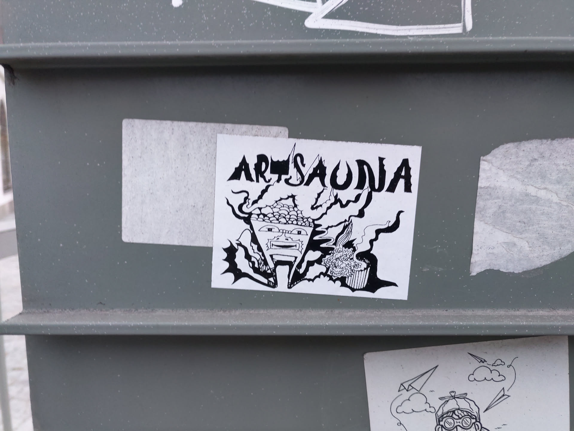 Black and white illustration sticker featuring a stylized face surrounded by abstract shapes and the word "Artsaudia".