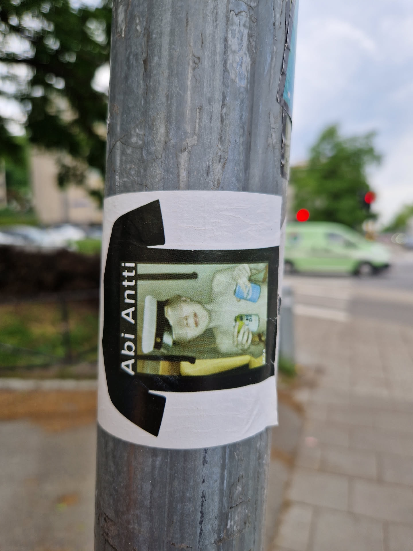 A sticker featuring a photo of a person in a sailor hat holding two drinks. The photo is set against a black t-shirt design.