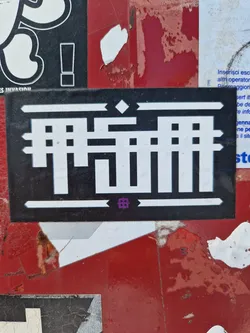 Black and white geometric abstract design sticker.  The sticker has a repeating pattern with rectangular shapes. There is no visible text except a possible stylized logo or symbol in the center.