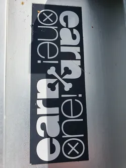 A black and white sticker with the text 'ear·one·carrie' arranged in a stylized design.  The text is surrounded by graphical elements, including an 'X' symbol.