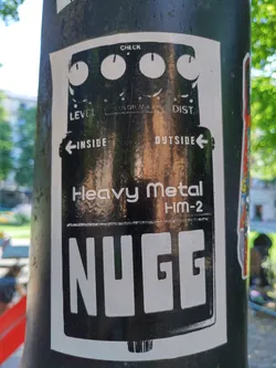 Black and white sticker depicting a guitar pedal with the text "NUGG" prominently displayed. The pedal is labeled "Heavy Metal HM-2".