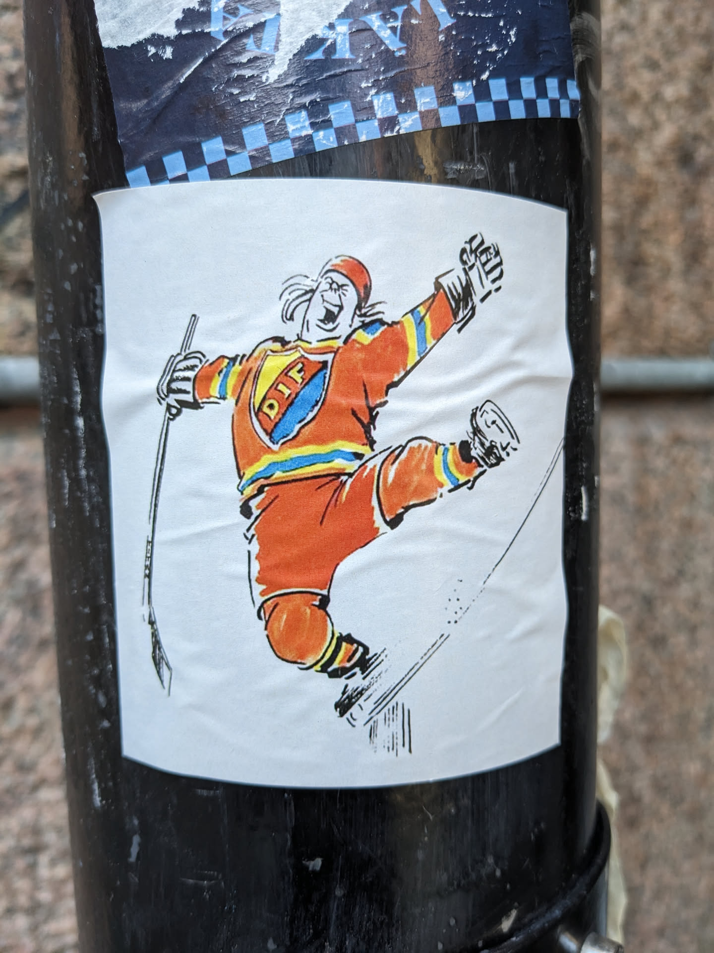 A sticker featuring a cartoon illustration of a hockey player in an orange jersey with blue and yellow accents, celebrating a goal. The jersey has the abbreviation "DIF" on it. The drawing style is reminiscent of older sports illustrations.