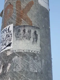 Black and white sticker with the word Brotherhood at the bottom and three figures in the center. The sticker has a grainy texture. The top right corner says DYS.