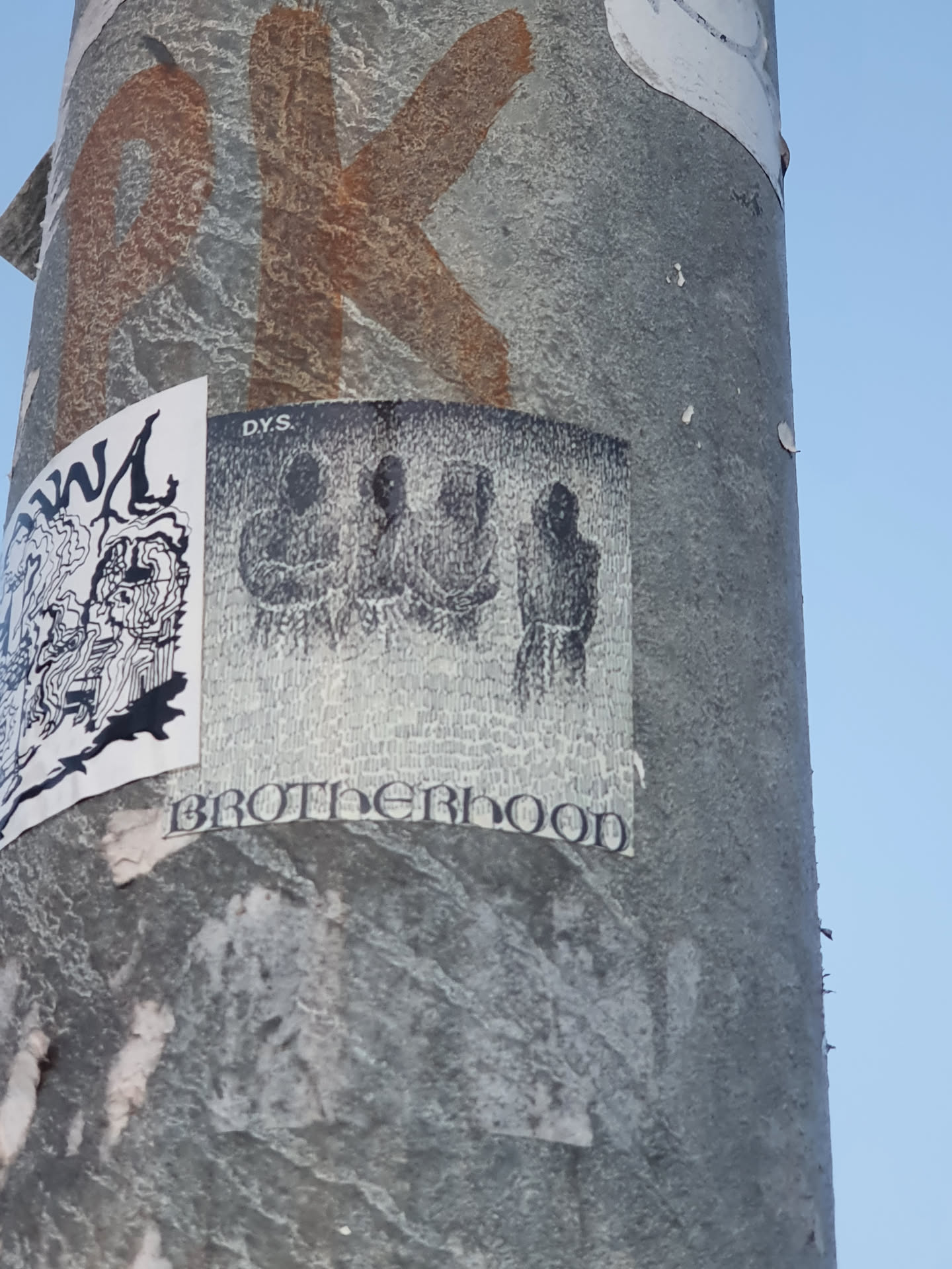 Black and white sticker with the word Brotherhood at the bottom and three figures in the center. The sticker has a grainy texture. The top right corner says DYS.