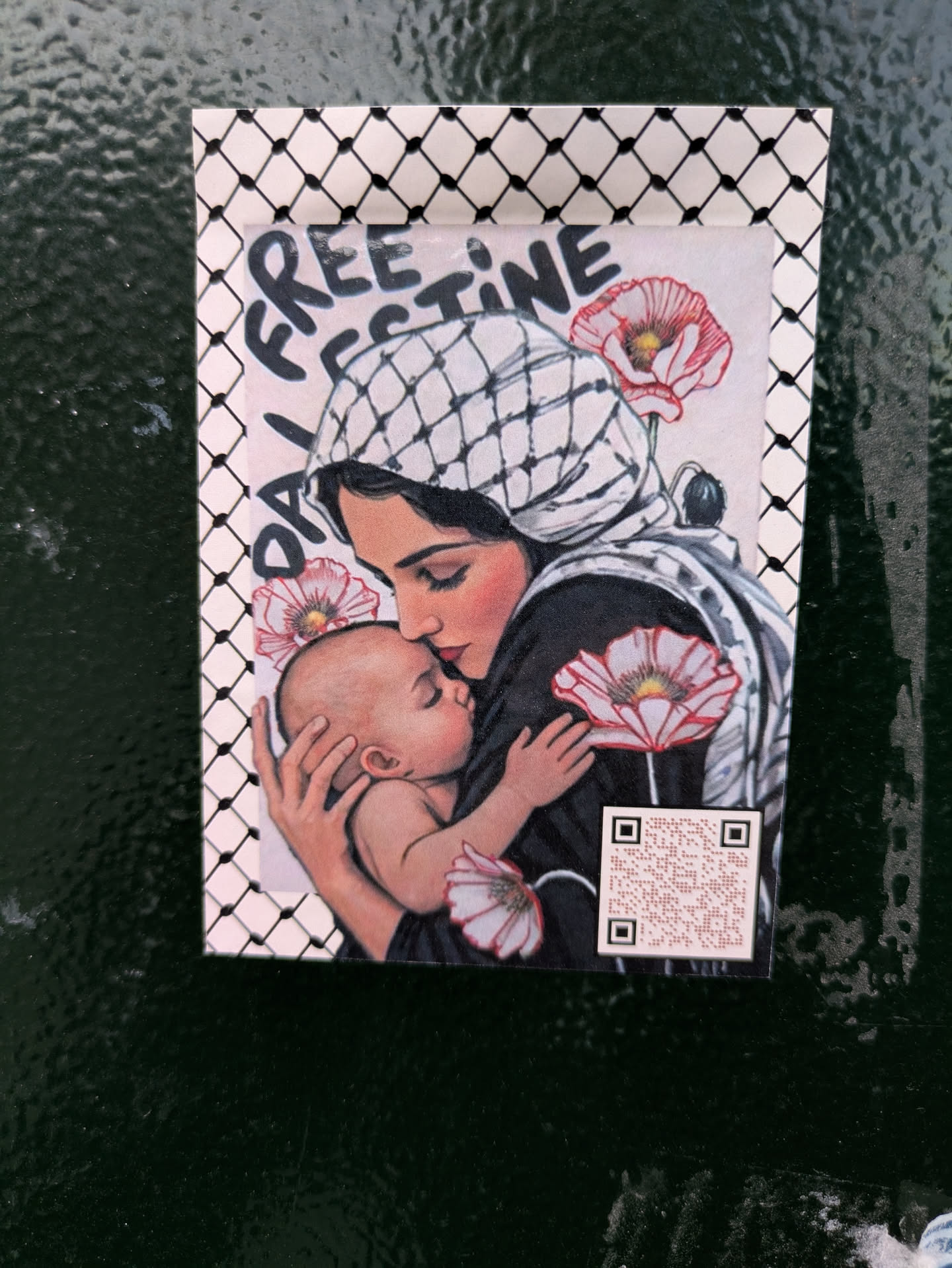 This sticker features an illustration of a woman wearing a keffiyeh, holding a baby, surrounded by red and white poppies. It is framed by a keffiyeh pattern. The sticker also says 'Free Palestine'. There's a QR code at the bottom right.