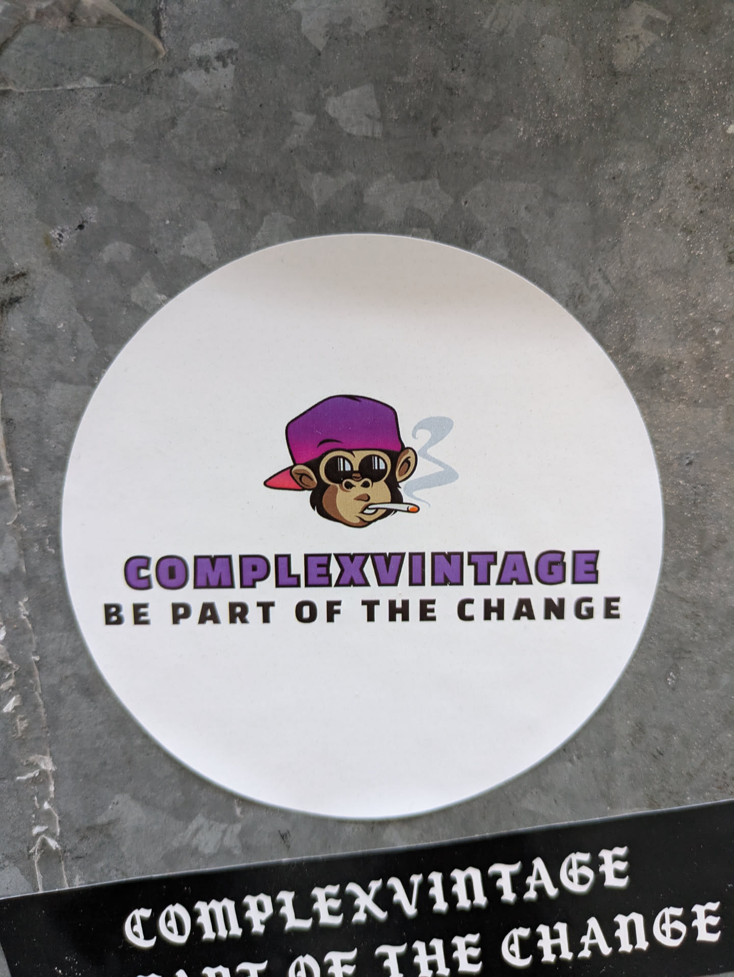 Round white sticker featuring a cartoon monkey wearing a purple hat and smoking a cigarette. The text 'Complexvintage' and 'Be part of the change' are written below the illustration.