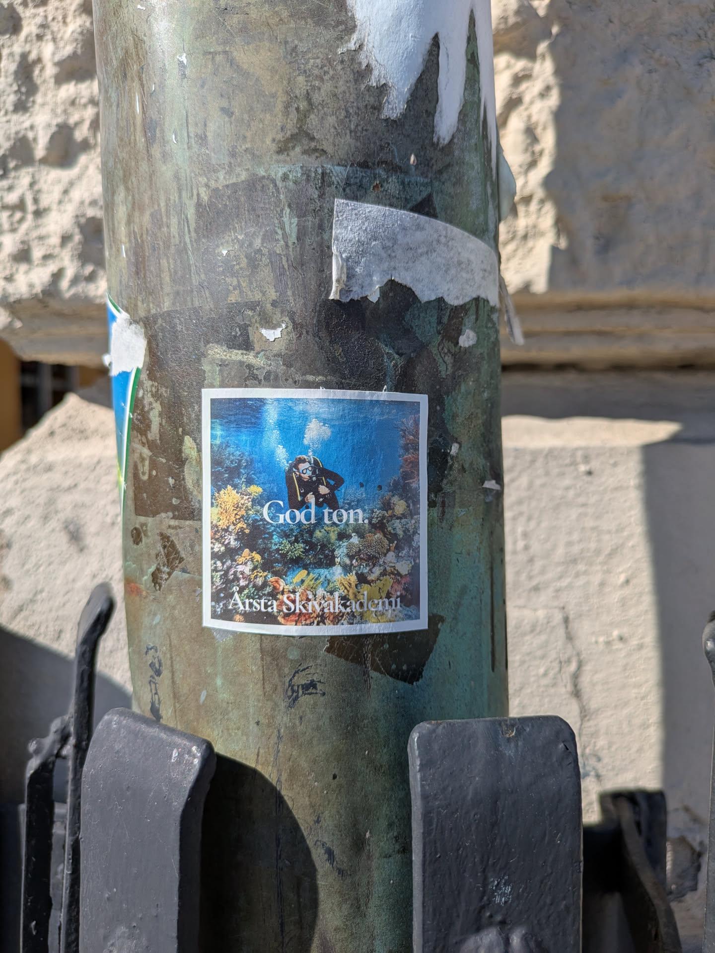 This sticker shows a scuba diver swimming underwater among coral reefs. The text "God ton" and "Arsta Skivakademi" are also printed on the sticker.