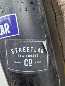 A black and white sticker for Streetlab Skateboard Co., established in Oslo, Norway. The sticker is slightly worn and dirty, showing signs of being stuck on a surface outdoors for a while. 