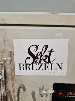 A sticker with the text "Sekt & Brezeln" in a stylized font. The Instagram handle @sektundbrezeln is also visible at the bottom of the sticker.
