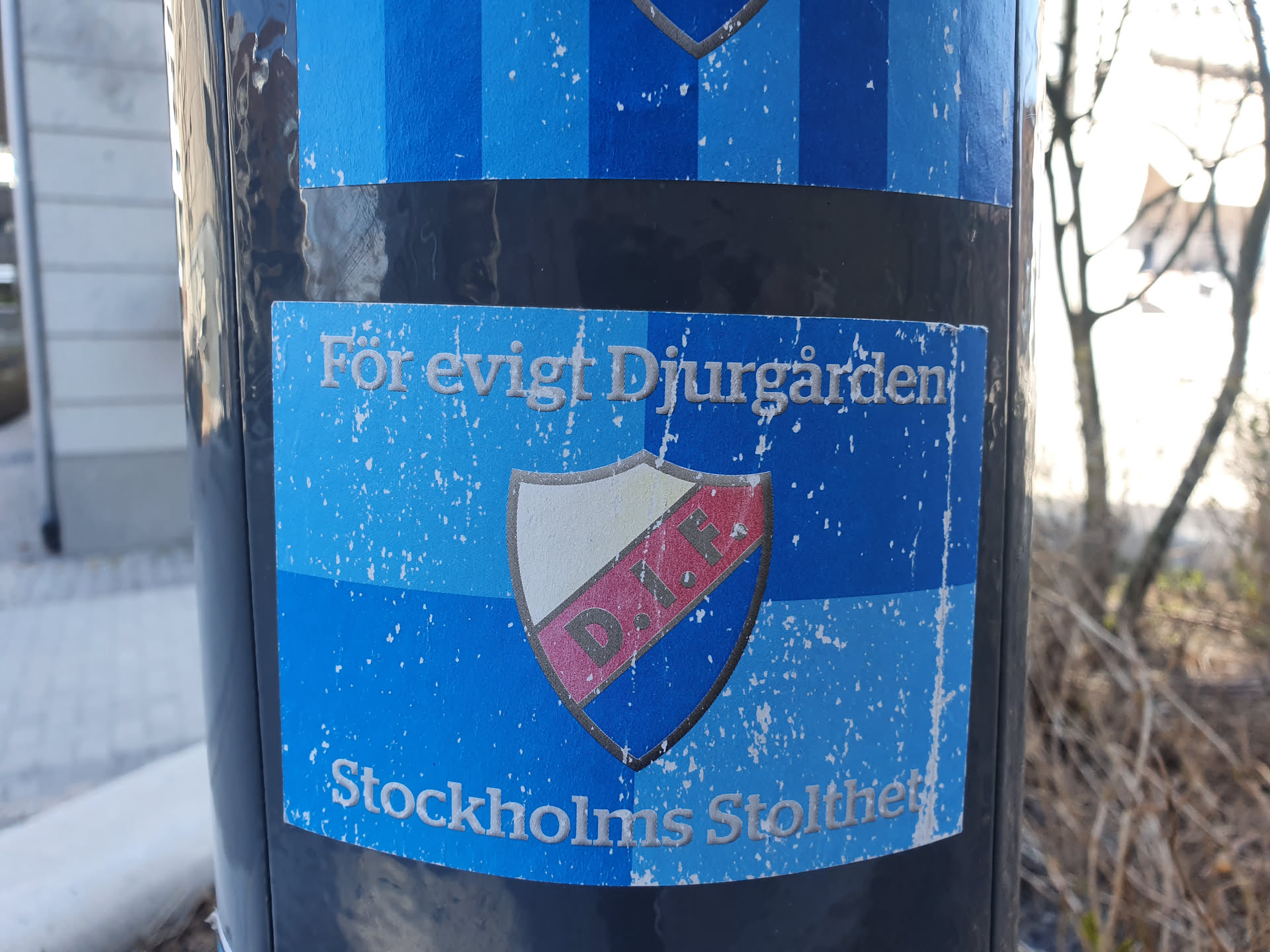 A worn-out sticker expressing loyalty to Djurgården, a Stockholm team. The sticker features the team's crest and the text "För evigt Djurgården!" which translates to "Forever Djurgården!" and "Stockholms Stolthet", which translates to "Stockholm's Pride".