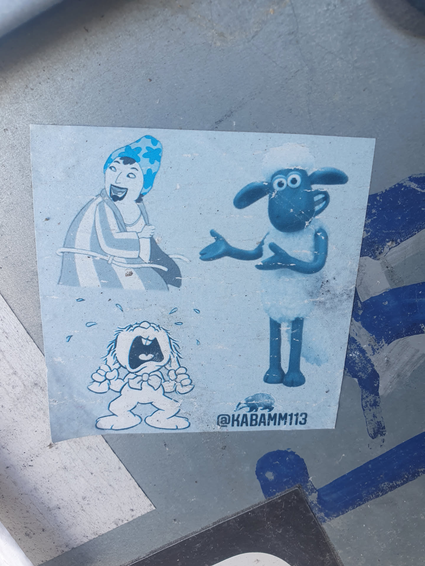 This sticker features a light blue color scheme and includes a variety of cartoon characters.  There's a depiction of Shaun the Sheep, a crying rabbit, and another character who appears to be wearing a blue hat.  The sticker also includes an Instagram handle.
