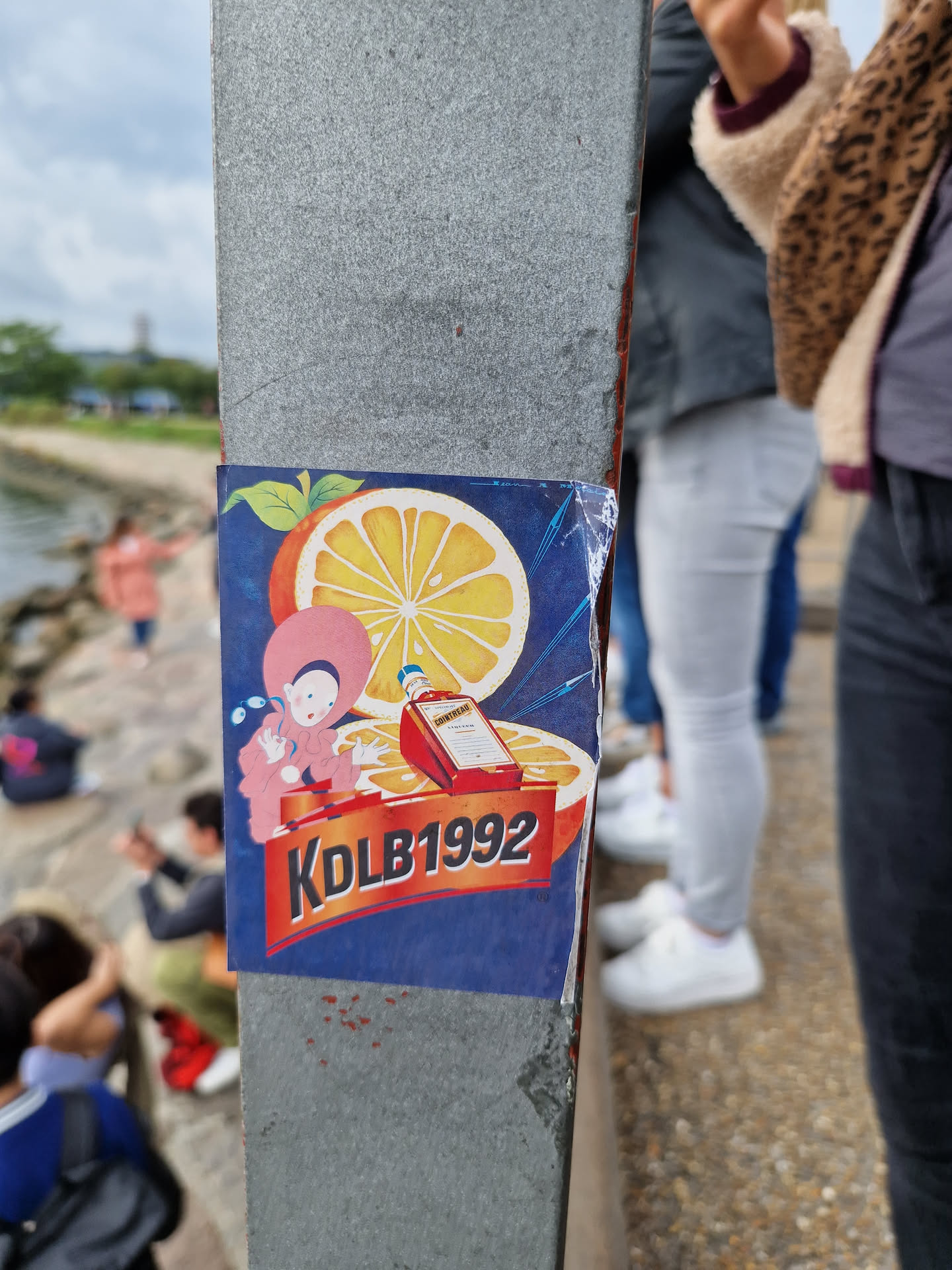 A sticker featuring a cartoon character, a Campari bottle, and oranges. The text 'KDLB1992' is prominently displayed on the sticker.
