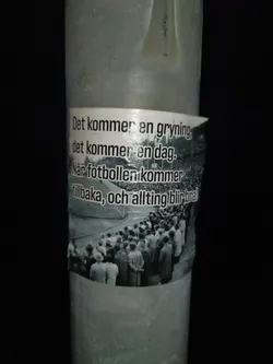 A sticker with a quote in Swedish about the return of football and better times. The sticker features a black and white image of a crowd of people at a stadium.