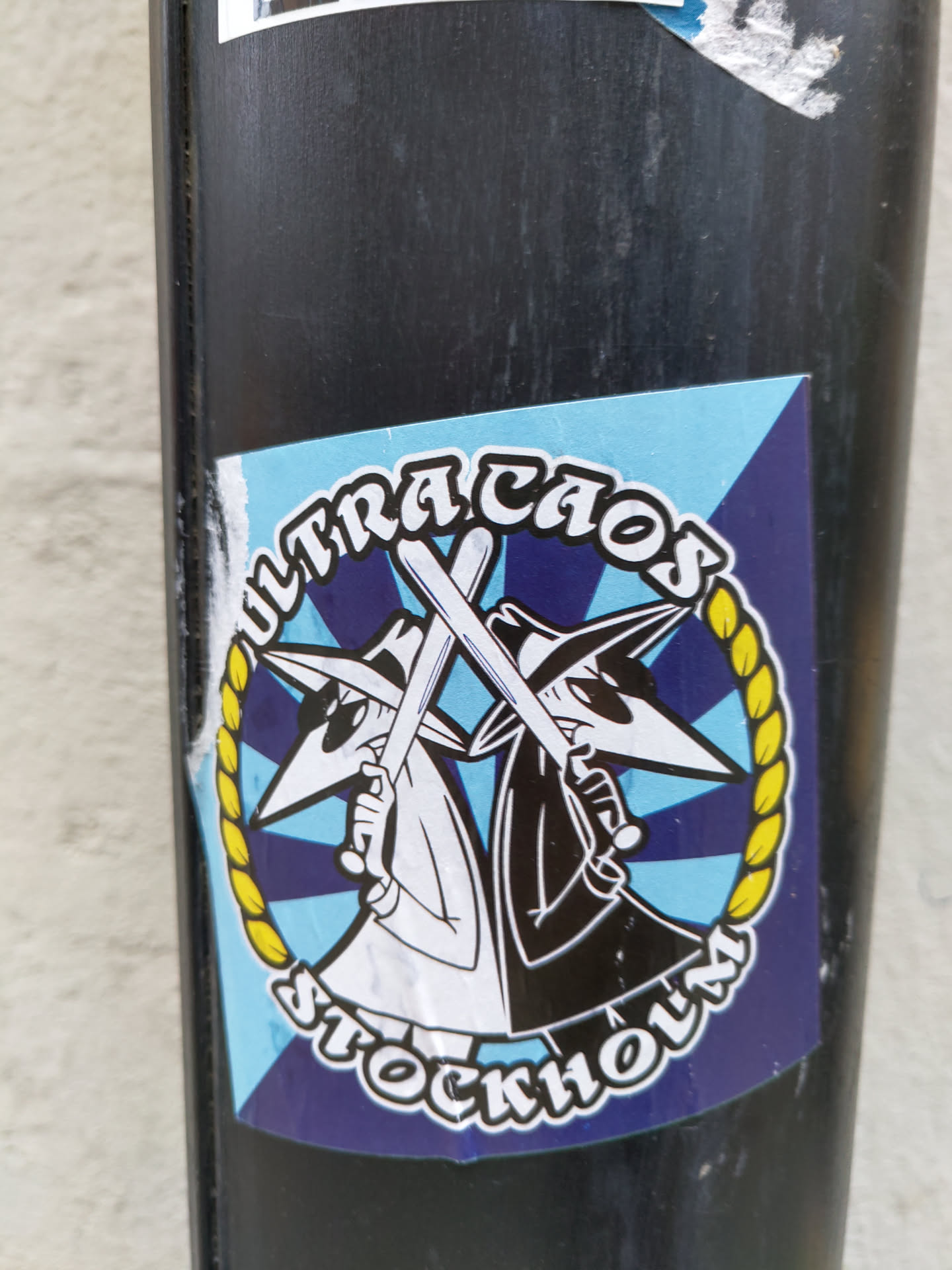 A sticker featuring two characters reminiscent of the Pink Panther, holding crossed bats, with the words "Ultra Caos Stockholm" written around them in a circular design.  The style is cartoonish and bold, with a retro color scheme.