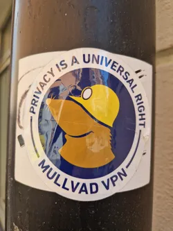 A round sticker with a cartoon mole wearing a yellow hard hat. The text on the sticker says "Privacy is a Universal Right" and "Mullvad VPN".